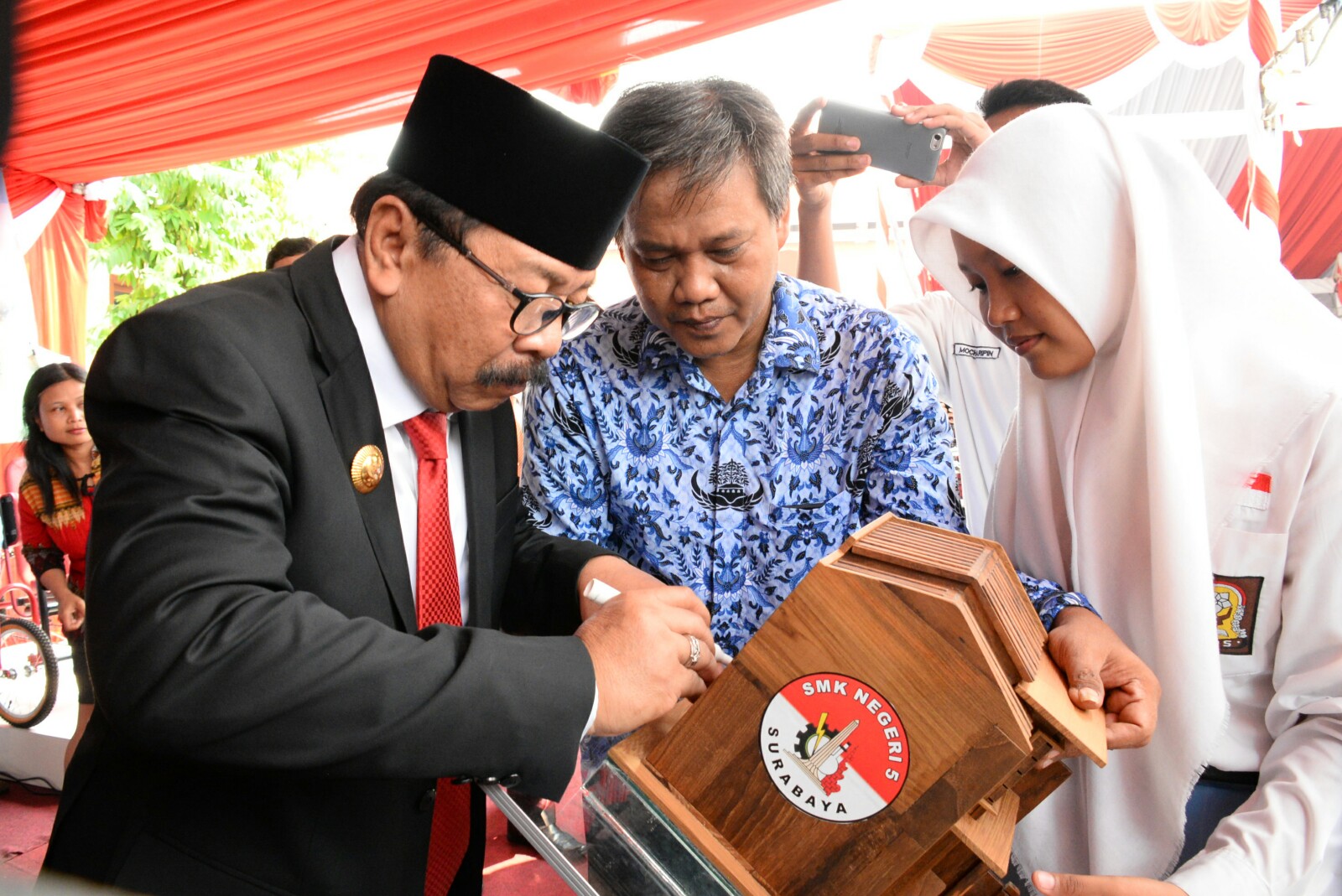 Pakde Karwo menandatangani hasil karya siswa SMK Negeri 5 Surabaya yang dipamerkan pada Upacara Hari Pendidikan Nasional Tahun 2017 di halaman Gedung Negara Grahadi Surabaya, Selasa (2/5)