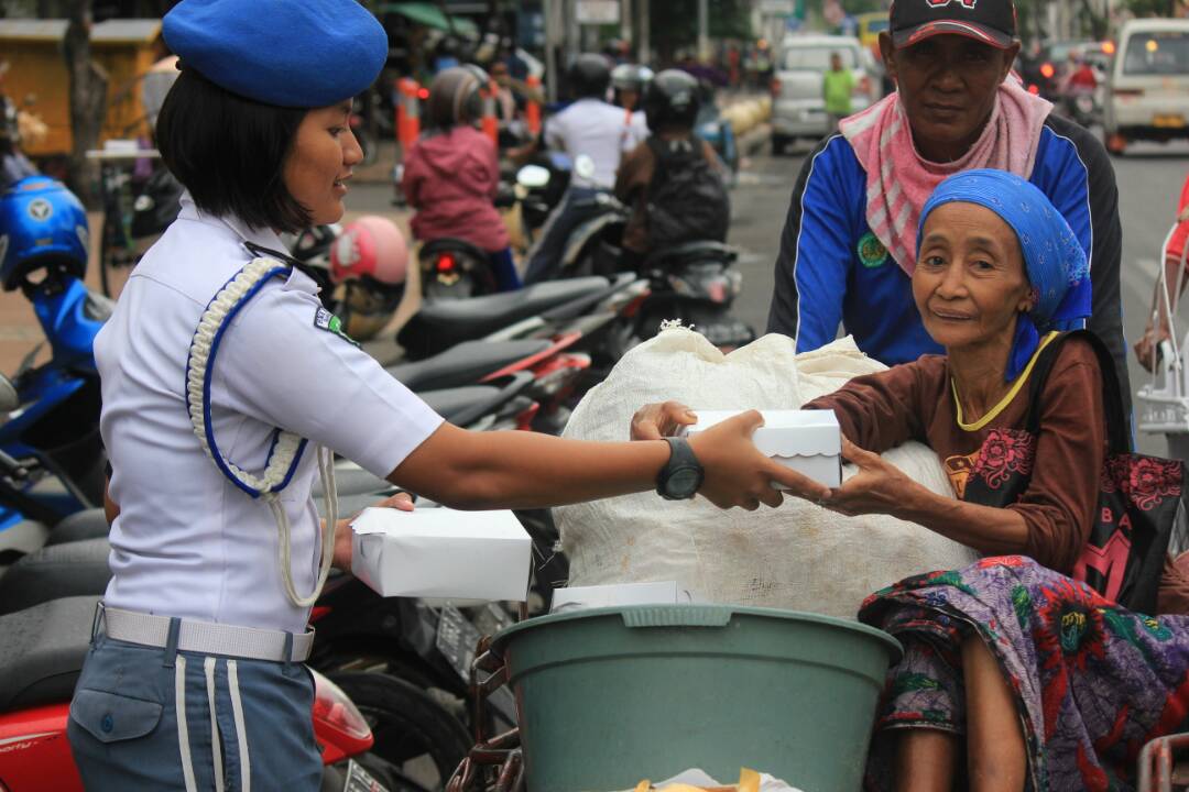 Salahsatu siswa yang tergabung dalam PASKAL-1 saat membagikan takjil di Jalan Rajawali Surabaya Selasa(13/6)