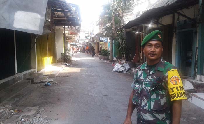 Seorang petugas dari tim Garnisun Surabaya mengawasi jalannya pembenahan di kampung Ampel Masjid Suarabaya, Jumat (7/7) siang. (foto: anis)