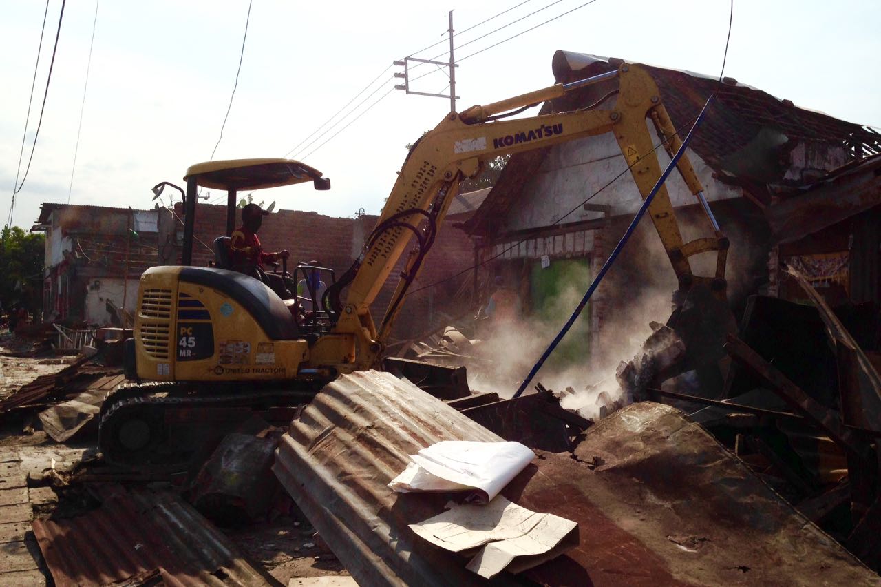 Alat berat berjenis eskavator merobohkan dan membersihkan setiap puing puing bangunan, disepanjang Jalan Pandegiling Surabaya. Senin (10/7). (Foto: frd)