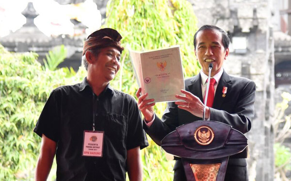 Presiden Joko Widodo menyerahkan sertifikat hak atas tanah program strategis nasional di Lapangan Renon, Kota Denpasar, Provinsi Bali, Jumat (4/8). (Foto: Biro Pers/Setpres)
