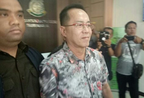 Ekspresi Henry J. Gunawan ketika digiring menuju mobil tahanan Kejari Surabaya, sore ini. 