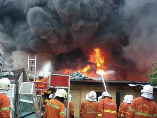 Api masih tampak membesar meludeskan sebuah gudang penyimpanan barang bekas di Kapas Madya