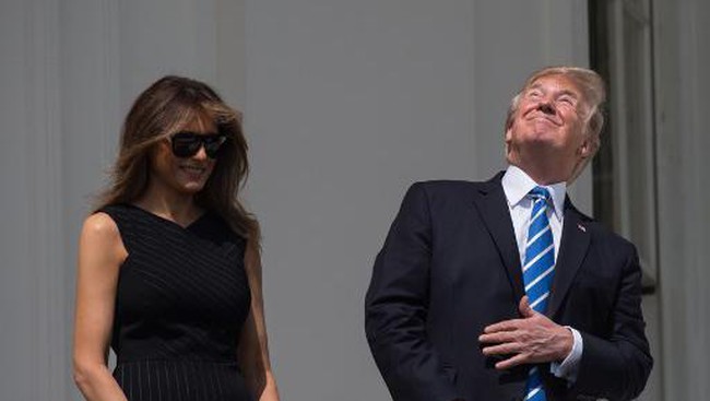 Disamping istrinya Trump terlihat secara langsung menatap matahari, bahkan di puncak gerhana matahari, tanpa kacamata pelindung apa pun, sebagaimana dilaporkan CNN, Senin (21/8) waktu setempat. (Foto: AFP)