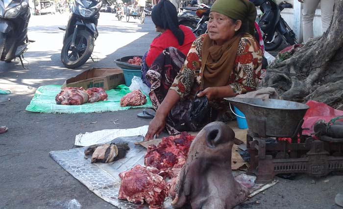 Seorang ibu menjual sekaligus membeli daging hasil Idul Adha, di Jl. Pegirian Surabaya, hari Jumat (1/9) siang. (foto:nis)