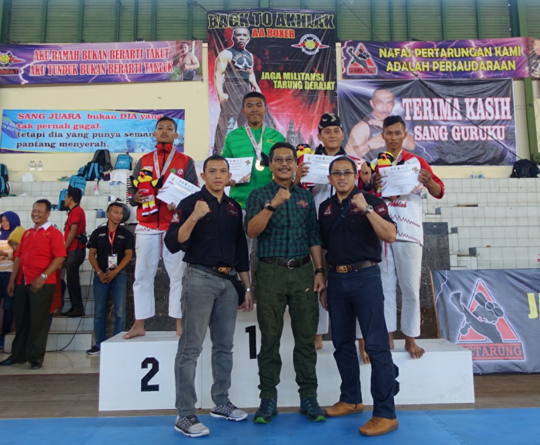 Petarung Jawa Timur Agung Tri berada di atas podium usai menerima medali emas dalam ajang POPNAS 2017 di GOR Satria Semarang. Foto:ngopibareng.id/tom