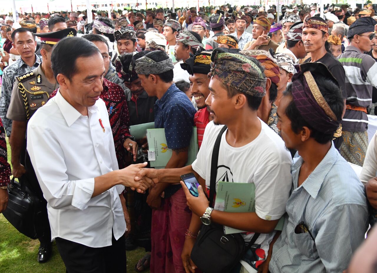 Presiden Joko Widodo menyerahkan sertifikat tanah kepada masyarakat di Taman Kota, Kabupaten Buleleng, pada Selasa siang, 26 September 2017. (Foto: Biro Pers/Setpres) 