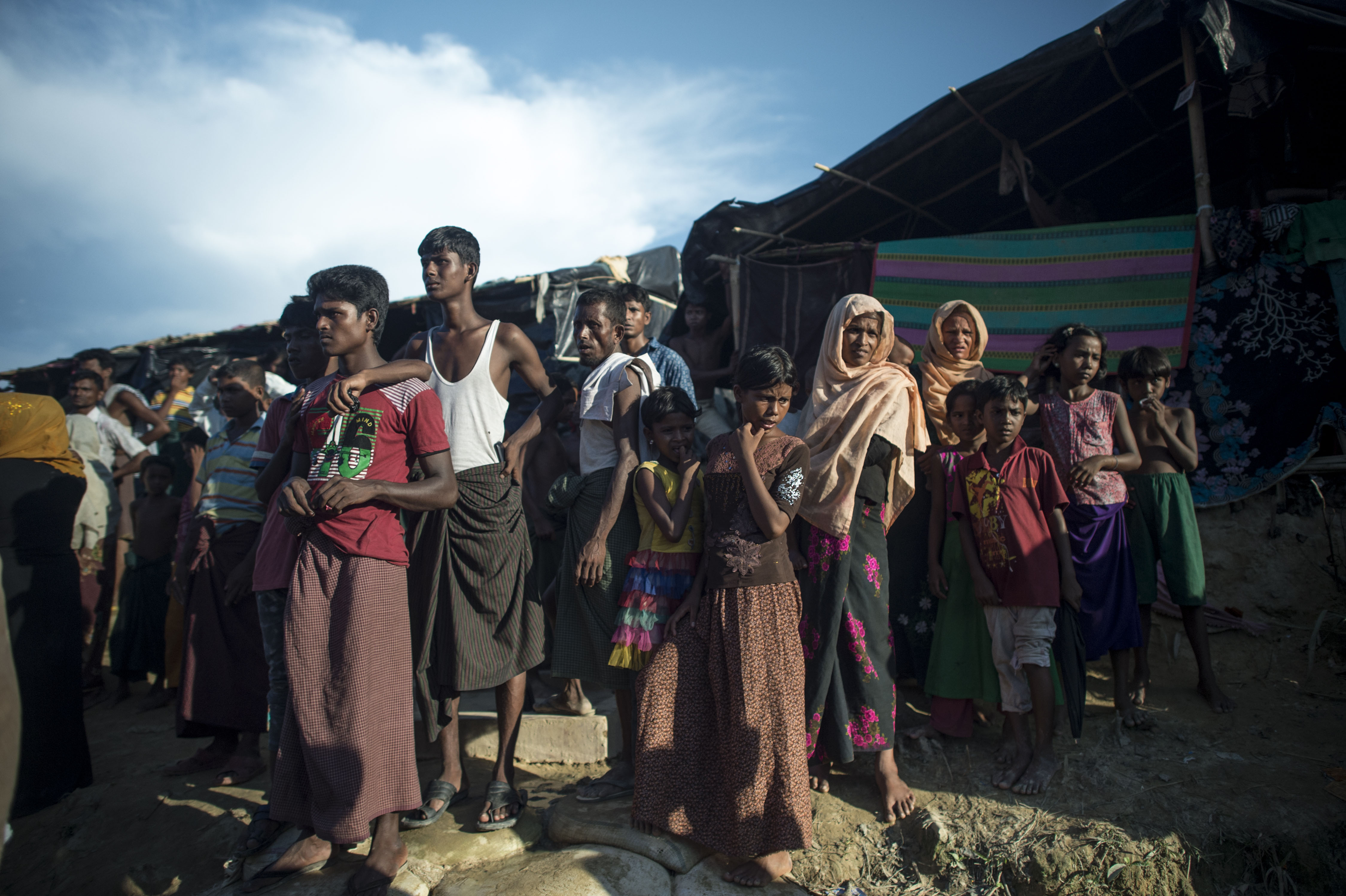 Pengungsi Rohingnya menyaksikan distribusi pangan di kamp pengunsi Balukhali di distrik Ukhia, 4 oktober 2017. Dalam satu bulan terakhir Lebih dari 500.000 warga muslim Rohingnya melarikan diri dari kekerasan berdarah di Myanmar dan angkanya kembali melonjak, dengan Bangladesh melaporkan kini 4.000-5.000 warga menyeberang setiap harinya setelah sempat mengalami jeda. (FRED DUFOUR/AFP)	 