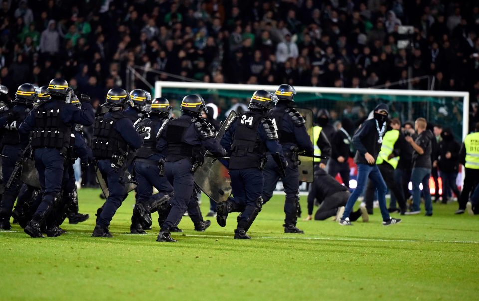 Polisi menghalau suporter yang masuk ke lapangan dalam laga St Etienne melawan Lyon di Liga Prancis, dini hari tadi. 