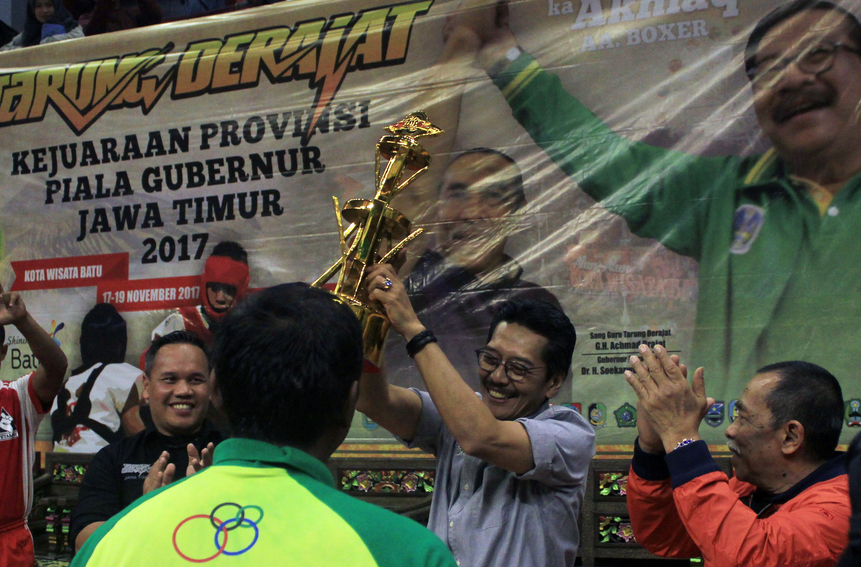 Ketua Harian Pengprov Kodrat Jatim, Erwin H.Poedjono menyerahkan Piala Gubernur Jawa Timur kepada kontingen tarung derajat Kota Kediri di GOR Gajah Mada, Kota Batu, tadi malam. 