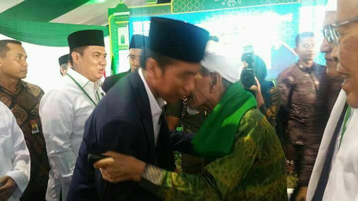 Presiden Jokowi bersalaman dengan KH Maimun Zubair saat Munas Alim Ulama di Mataram, Jumat (24/11).
