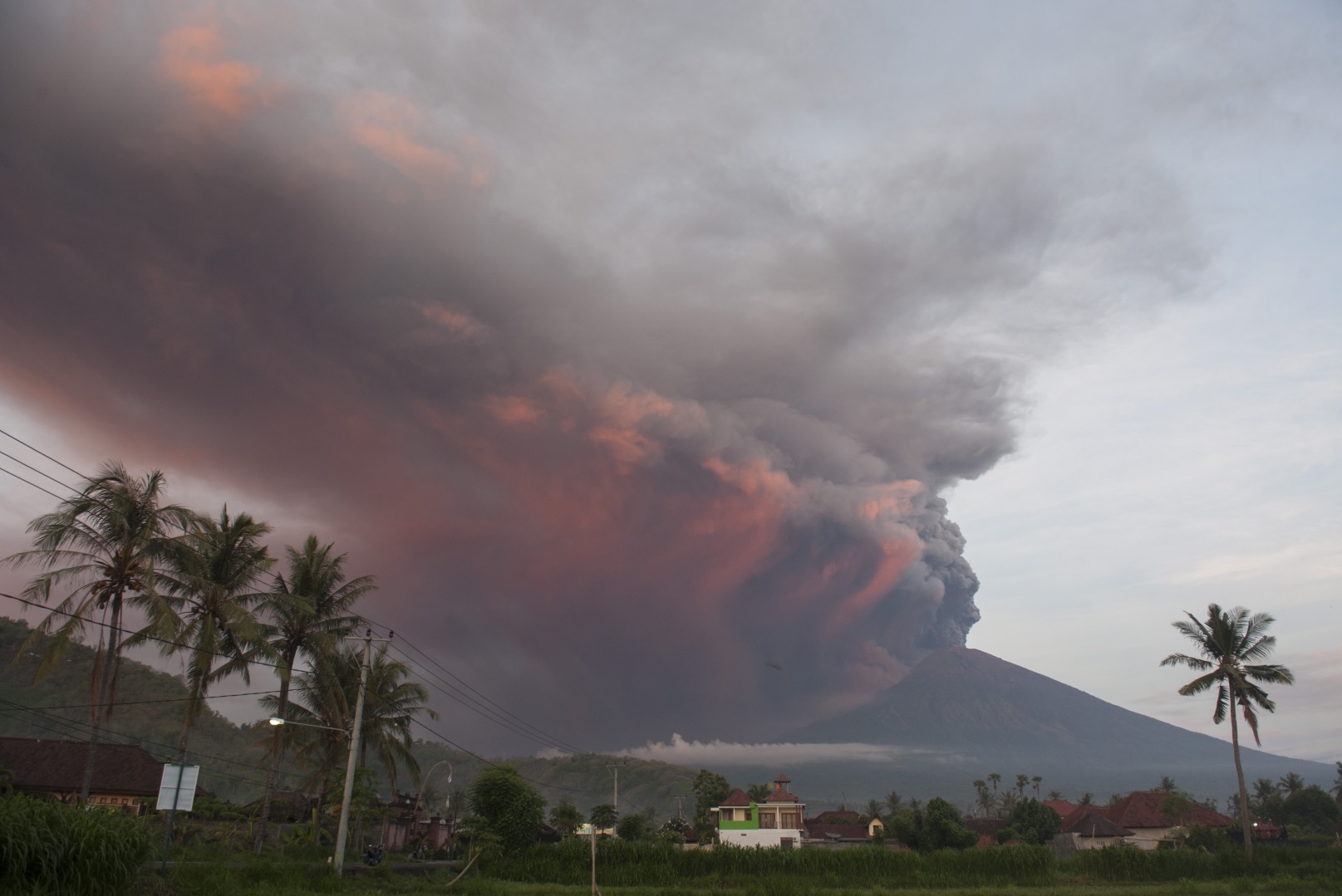 Asap dan abu vulkanis menyembur dari kawah Gunung Agung pascaletusan freatik kedua, terpantau dari Desa Culik, Karangasem, Bali, Minggu (26/11). Pusat Vulkanologi dan Mitigasi Bencana Geologi menyatakan telah terjadi letusan freatik kedua pada pukul 17.20 Wita yang disusul dengan semburan asap dan abu vulkanis hingga ketinggian 3.000 meter. (Foto: ANTARA FOTO/Nyoman Budhiana)