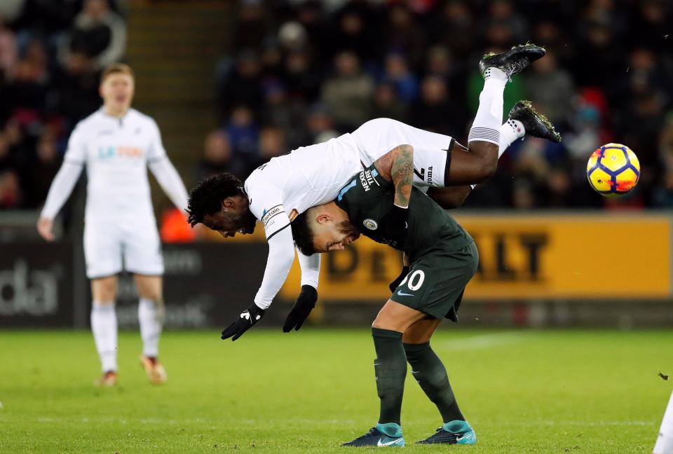 Pemain Manchester City, Kun Aguero menghindari terjangan pemain Swansea Wlfried Bony dalam lanjutan Liga Inggris, dini hari tadi.