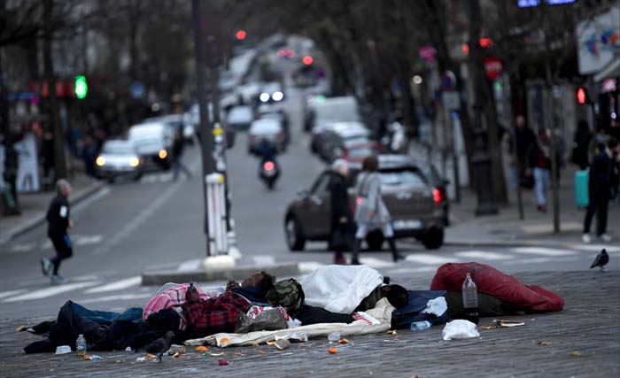 Dua orang tunawisma berbaring di dekat persimpangan jalan di Paris hari Minggu 24 Desember 2017 kemarin.  Mereka enak saja tidur di jalan padahal suhu udara bisa 5 atau bahkan 3 derajat. (foto: stephane de sakutin/afp) 