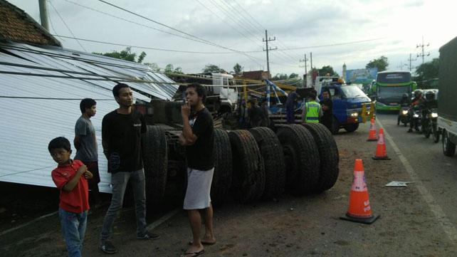 Kecelakaan truk trailer muat backhoe di Pendem Batu. (Foto: Cholis warga Batu) 