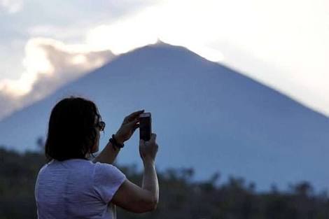 Seorang turis mengabadikan letusan gunung Agung. (Foto : Antara)