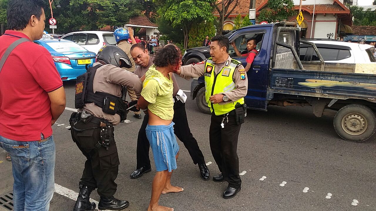 Pihak Kepolisian mengamankan Gatot Sugeng Prayitno (47), membawa dua botol molotov, berisi bensin dan korek gas, didepan Gedung Negara Grahadi,  Sabtu, 6 Januari 2018. (Foto: Istimewa)