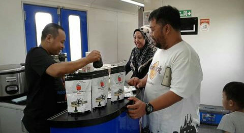 Aziz, owner sekaligus barista di Street Coffee Blitar sedang memanjakan penumpang KA Gajayana dengan kopi specialtynya. Foto:Istimewa