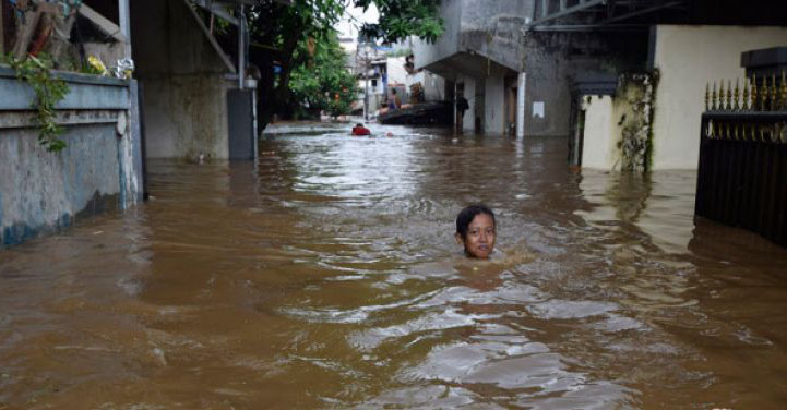 Seorang anak melintasi banjir sedalam 1,5 meter di Kelurahan Pajetan Timur, Pasar Minggu, Jakarta Selatan, Senin 5 Februari. Banjir yang terjadi di kawasan tersebut akibat luapan air dari Sungai Ciliwung. (Foto: Antara)