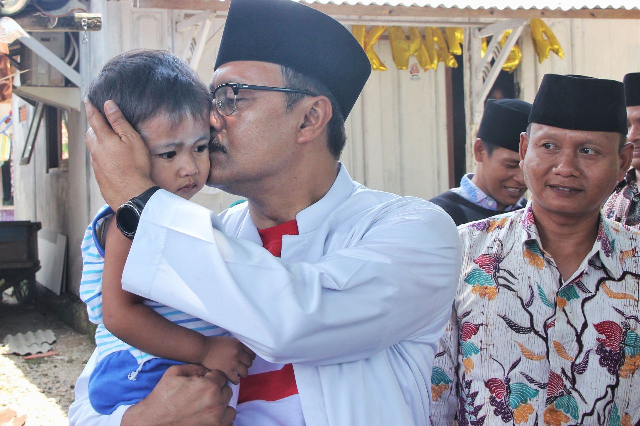 Cagub Jatim Saifullah Yusuf mencium anak yang baru ditimbang di sebuah Posyandu di Bangkalan. (Foto : istimewa)