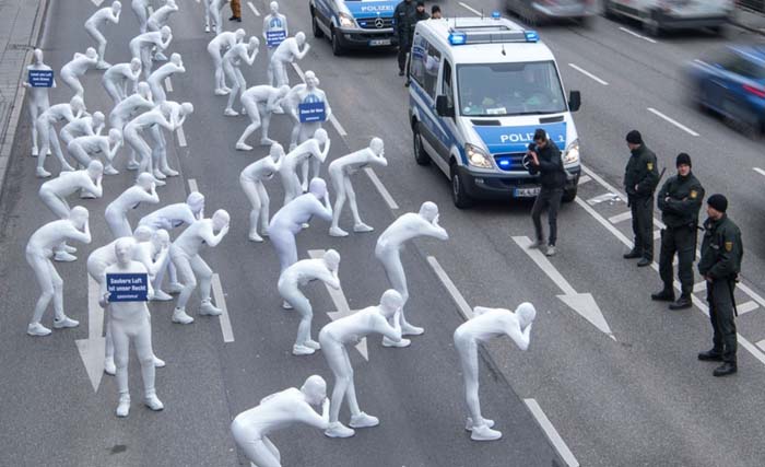Para aktivis lingkungan "Greenpeace" berpakaian putih-putih melakukan aksi protes terhadap polusi udara oleh gas buang diesel di kota Stuttgart, Jerman selatan, pekan lalu. (foto: voa).