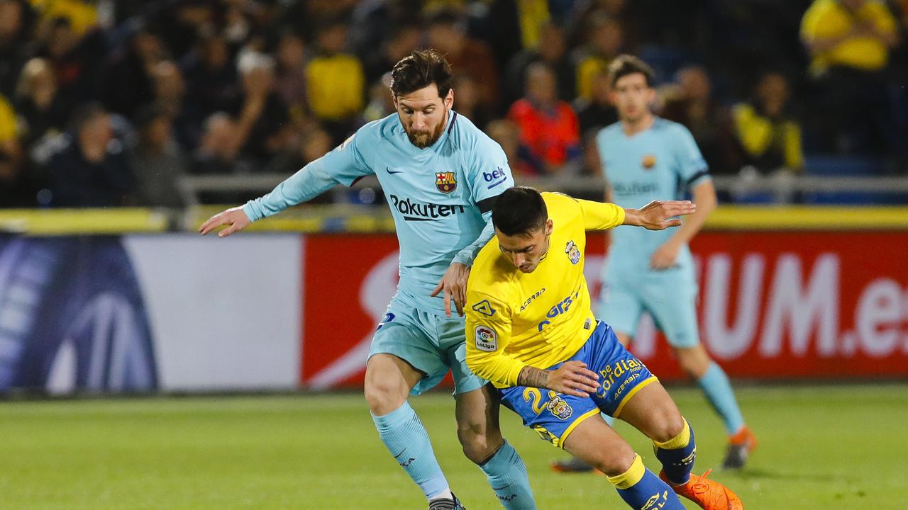 Bintang Barcelona, Lionel Messi, berebut bola dengan pemain Las Palmas, Ximo Navarro, dalam laga yang berkesudahan 1-1 di Estadio Gran Canaria, Kamis 1 Maret 2018. (AP Photo)