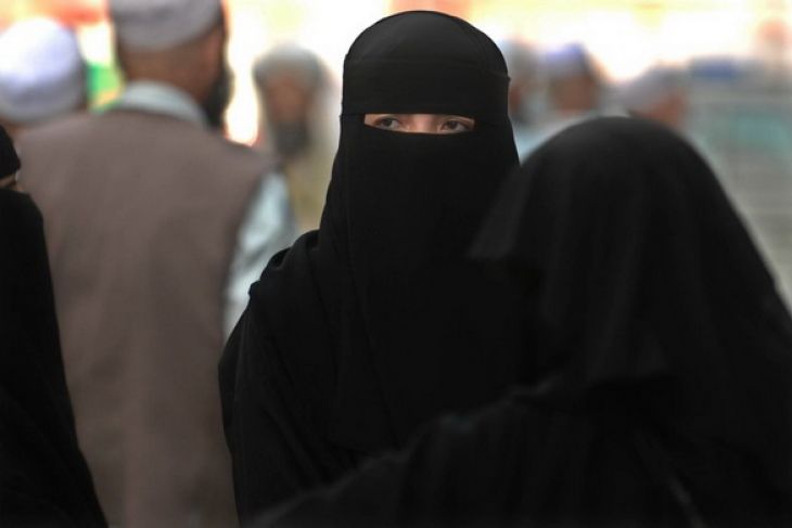 Sejumlah wanita mengenakan cadar ketika melintas di kawasan perdagangan di Misfalah, Makkah. Cadar adalah pakaian adat warga negara-negara Arab dan umumnya berwarna hitam. (Foto: Antara)
