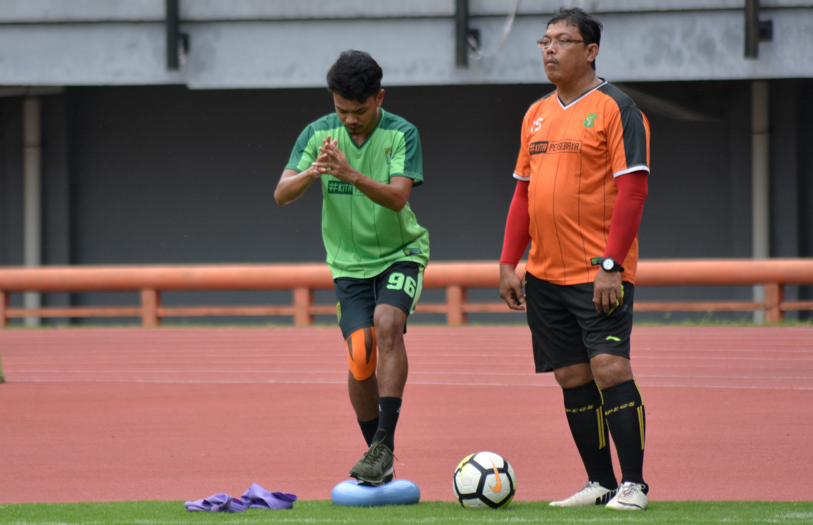 Pemain Persebaya M. Hidayat (hijau) saat menjalani terapi dengan didampingi tim dokter di Stadion Gelora Bung Tomo. (foto: hrs/ngopibareng)