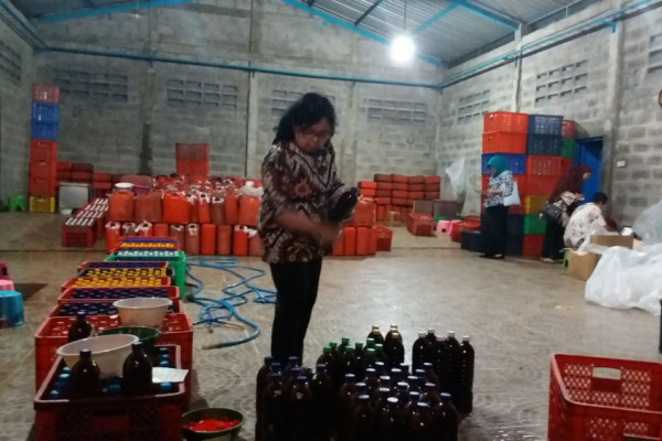 Petugas BPOM Surabaya melihat botol dan jeriken yang berisi jamu dengan komposisi yang diduga tidak sesuai dengan peruntukannya, Kamis 22 Maret 2018. (Foto: Antara)