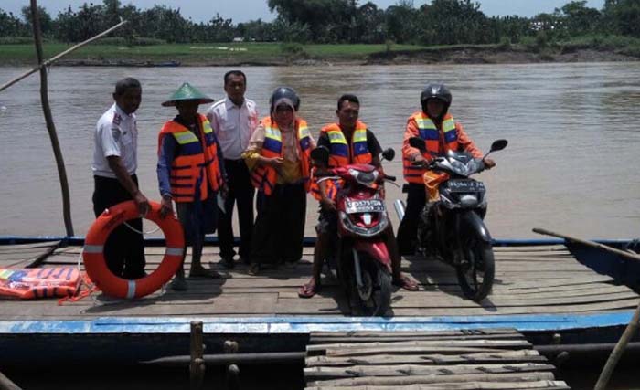 Penumpang perahu tambang  mengenakan baju pelampung di lokasi tambangan Bengawan Solo di Kecamatan Balen, Bojonegoro, Selasa 27 Maret 2018. (foto:slamet agus sudarmojo)