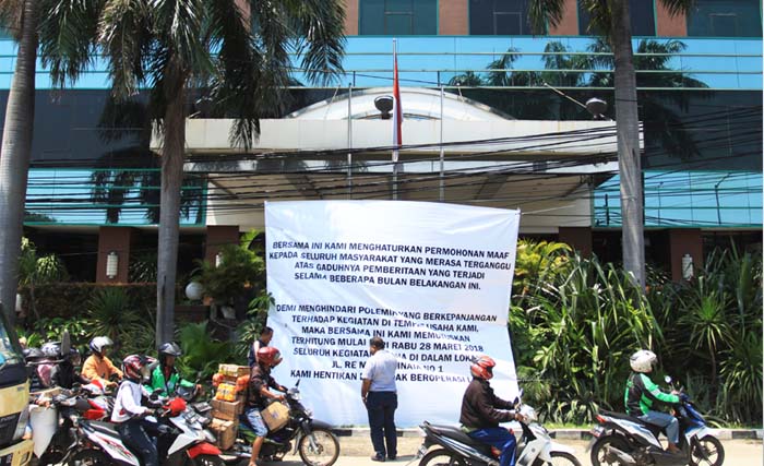 Sejumlah warga melintas di depan spanduk pengumuman penghentian operasional Hotel Alexis di Jalan RE Martadinata, Jakarta, Rabu 28 Maret 2018.  (foto: reno esnir/antara)