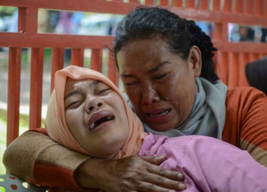 Keluarga dari korban meninggal akibat keracunan minuman keras (miras) oplosan menangis histeris di depan ruang Unit Gawat Darurat Rumah Sakit Umum Daerah (RSUD) Cicalengka, Kabupaten Bandung, Jawa Barat, Senin 9 April, 2018). (Foto: Antara)