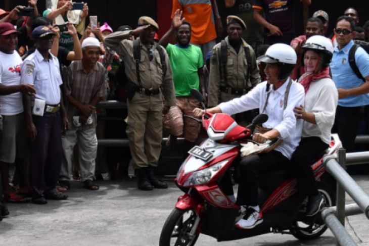 Presiden Joko Widodo dan Ibu Negara Iriana Joko Widodo keliling Kabupaten Asmat di Papua dengan berboncengan mengendarai sepeda motor listrik. (Biro Pers Istana Kepresidenan)