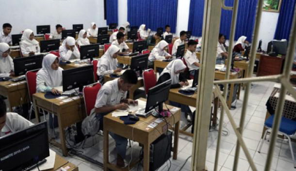 Sejumlah siswa kelas 12 mengerjakan soal ujian nasional mata pelajaran matematika pada malam hari di SMA N 2 Purbalingga, Jawa Tengah, Selasa 10 April 2018. (Foto: Antara)