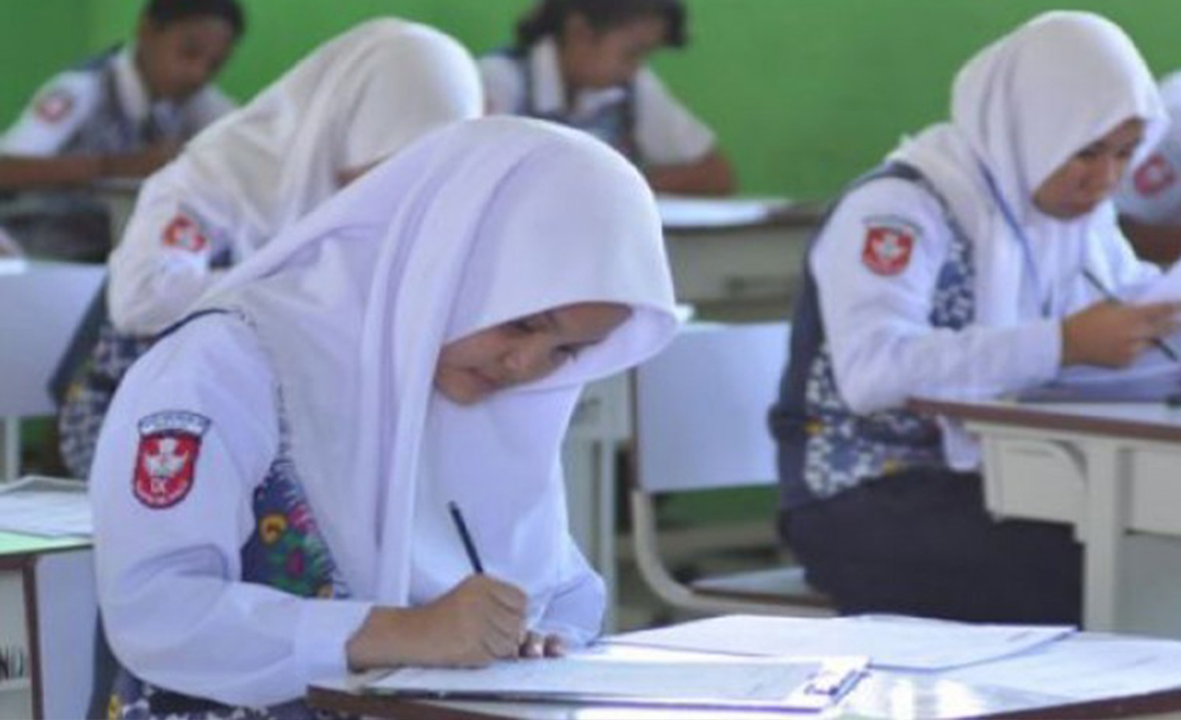 Pelajar SMP Negeri 18 Palu mengerjakan soal ujian nasional dengan skema ujian nasional berbasis kertas dan pensil (UNKP) di SMP Negeri 18 Palu, Kelurahan Mamboro, Palu Utara, Sulawesi Tengah, Senin 23 April. ( Foto: Antara) 