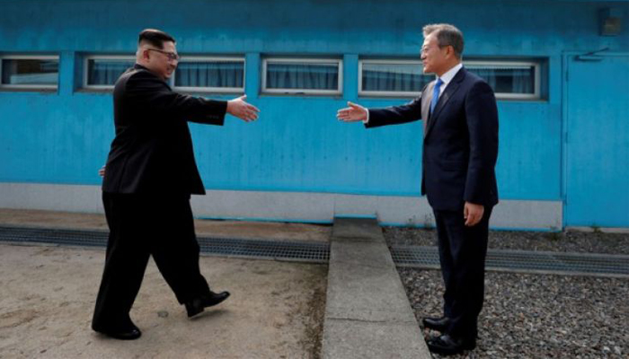Presiden Korea Selatan Moon Jae-in dan pemimpin Korea Utara Kim Jong Un berjabat tangan di desa gencatan senjata Panmunjom di dalam zona demiliterisasi yang memisahkan dua Korea, Korea Selatan, Jumat (27 April 2018. (Foto: Korea Summit Press Pool/Pool via Reuters)