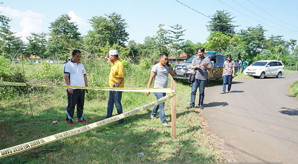 Polisi memasang garis polisi di lokasi pembacokan ketua PPK Galis, Bangkalan, Madura. (Foto: Polres Bangkalan)