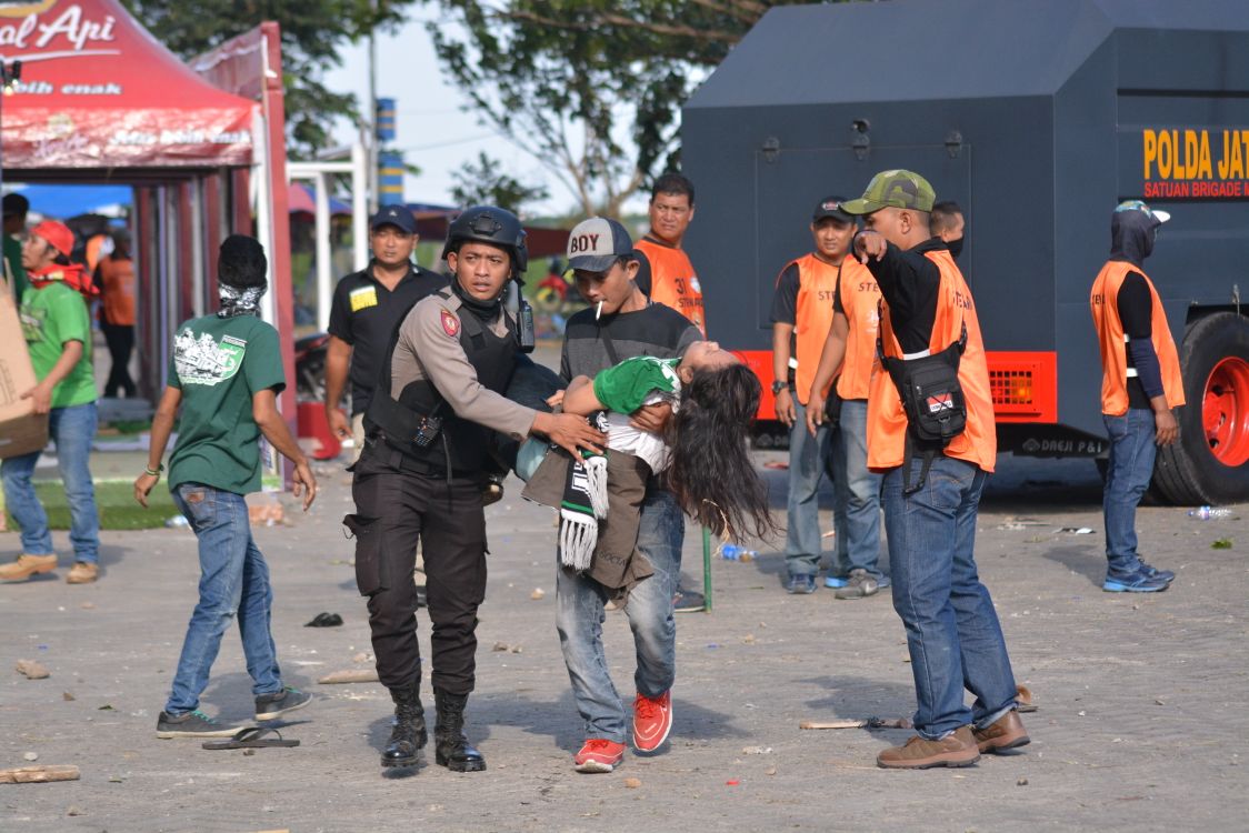 Salah satu bonek wanita korban bentrokan  di luar Stadion GBT mendapatkan perawatan. foto;hrs/ngopibareng.id