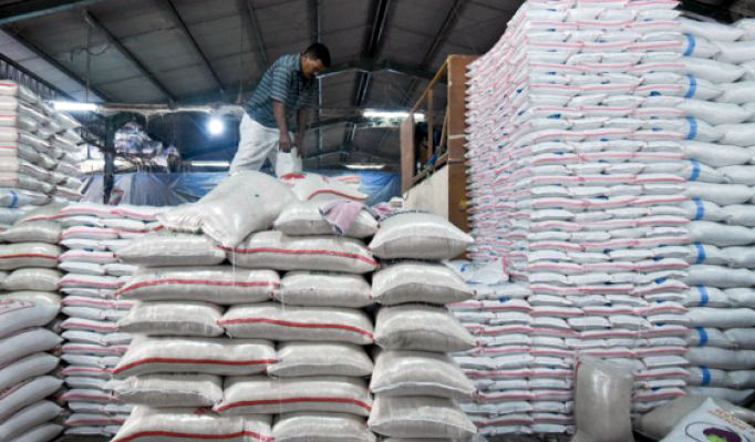 Seorang pekerja tengah menata beras di gudang beras milik Bulog. (Foto: Antara)