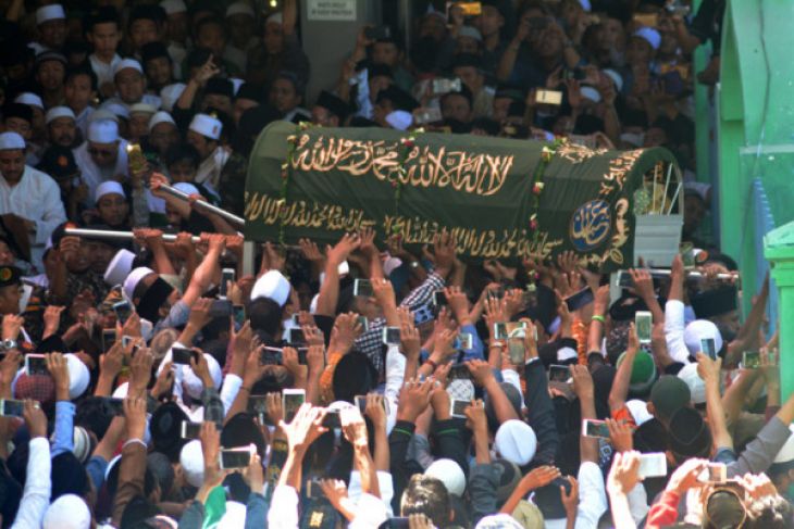 Santri dan pelayat menggotong peti jenazah KH Sholeh Qosim saat akan dimakamkan di Kompleks Pondok Pesantren Bahauddin Al-Islami, Ngelom, Sepanjang, Sidoarjo, Jawa Timur, Jumat 11 Mei 2018. Pengasuh Pondok Pesantren Bahauddin Al-Islami tesebut wafat di usia 90 tahun pada Kamis 10 Mei 2018 saat menjalankan Salat Maghrib. (Foto: Antara)