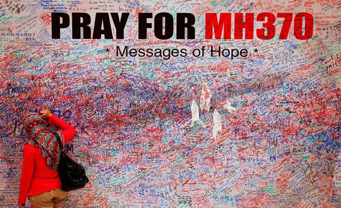 Seorang wanita menuliskan pesan dan harapan di booth yang dipasang di pusat kota Kualam Lumpur, bagi para penumpang Malaysia Airlines MH370 yang hilang sejak Maret 2014. (foto: reuter)