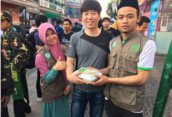 SIMPATI: Para aktivis NU di Korea Selatan sedang membagikan takjil pada Muslim di Negeri Ginseng itu. (foto: ist)