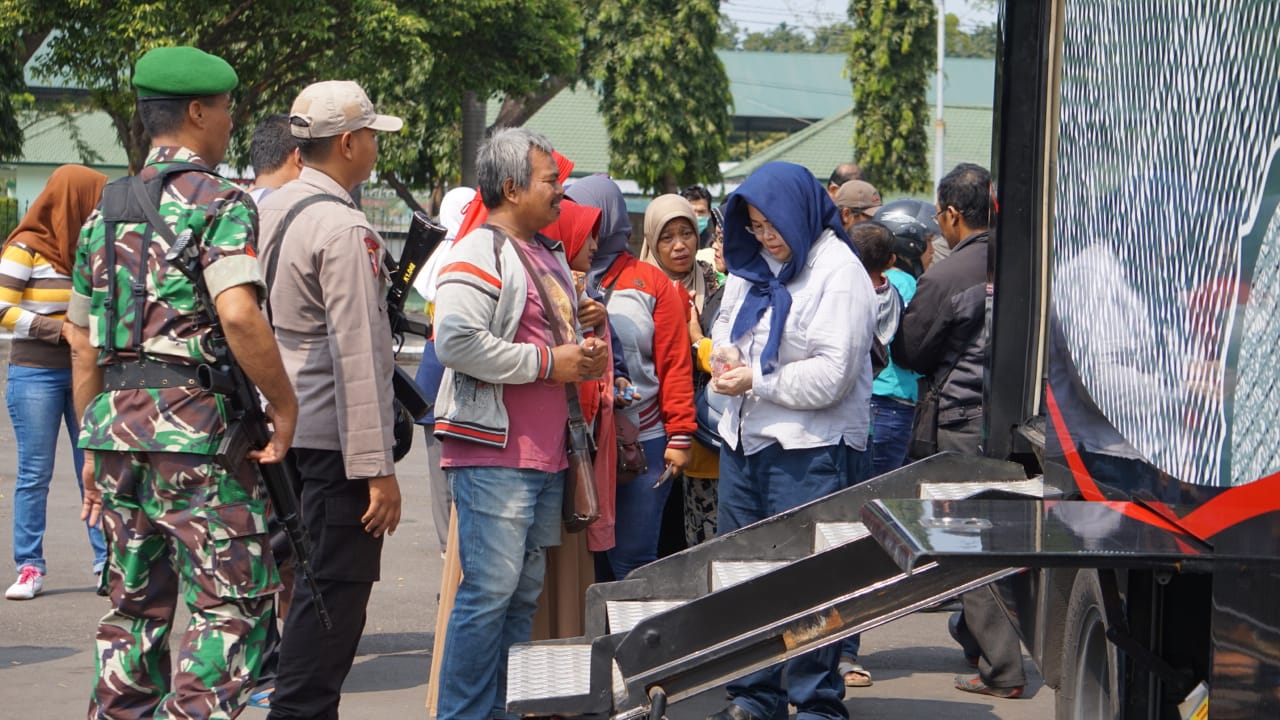 Masyarakat yang rela mengantre untuk menukarkan uang baru di lapangan Makodam V Brawijaya, Surabaya.