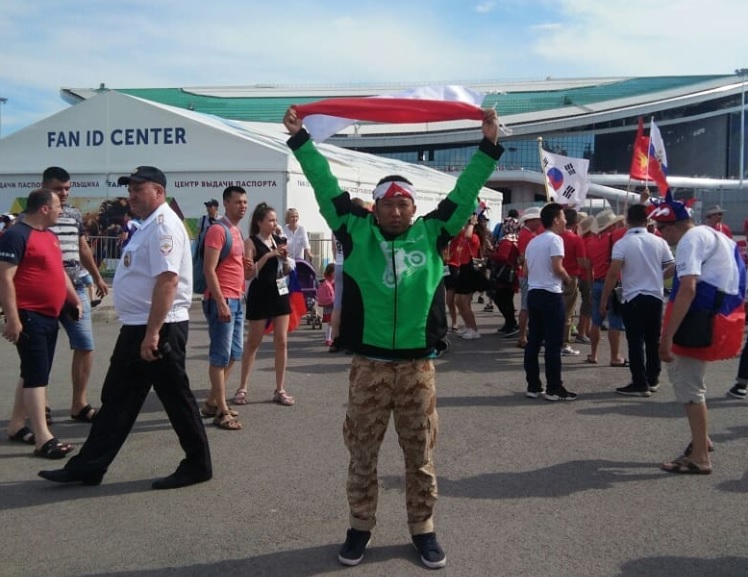 Roy Sunandar bangga beratribut driver ojek online (ojol) dan bendera Indonesia merah putih berpose di depan Kazan Arena,Rusia.