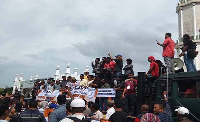 Koalisi Masyarakat Aceh Bersatu (KMAB) melakukan aksi di depan Masjid Raya Baiturrahman Kota Banda Aceh, Senin 9 Juli 2019, menuntut KPK untuk membebaskan Irwandi Yusuf. (foto:iglobalnews)