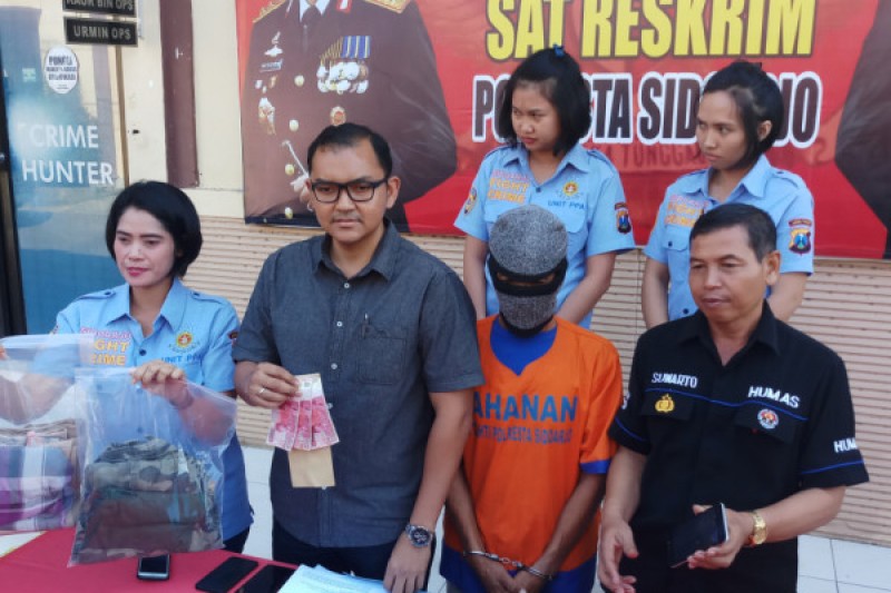 Petugas Satreskrim Polresta Sidoarjo menunjukkan barang bukti pelaku perdagangan orang, Selasa 10 Juli 2018. (Foto: Antara)