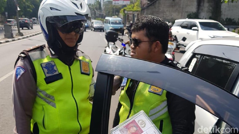 Joseph Anugerah (tanpa helm) saat diiamankan petugas dari Polda Metro Jaya. foto: Traffic Management Center (TMC) Polda Metro Jaya.