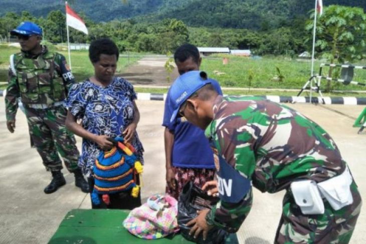 Satgas perbatasan Yonif 501/Kostrad mengamankan seorang warga Papua Nugini karena membawa narkoba. (Foto: Antara)