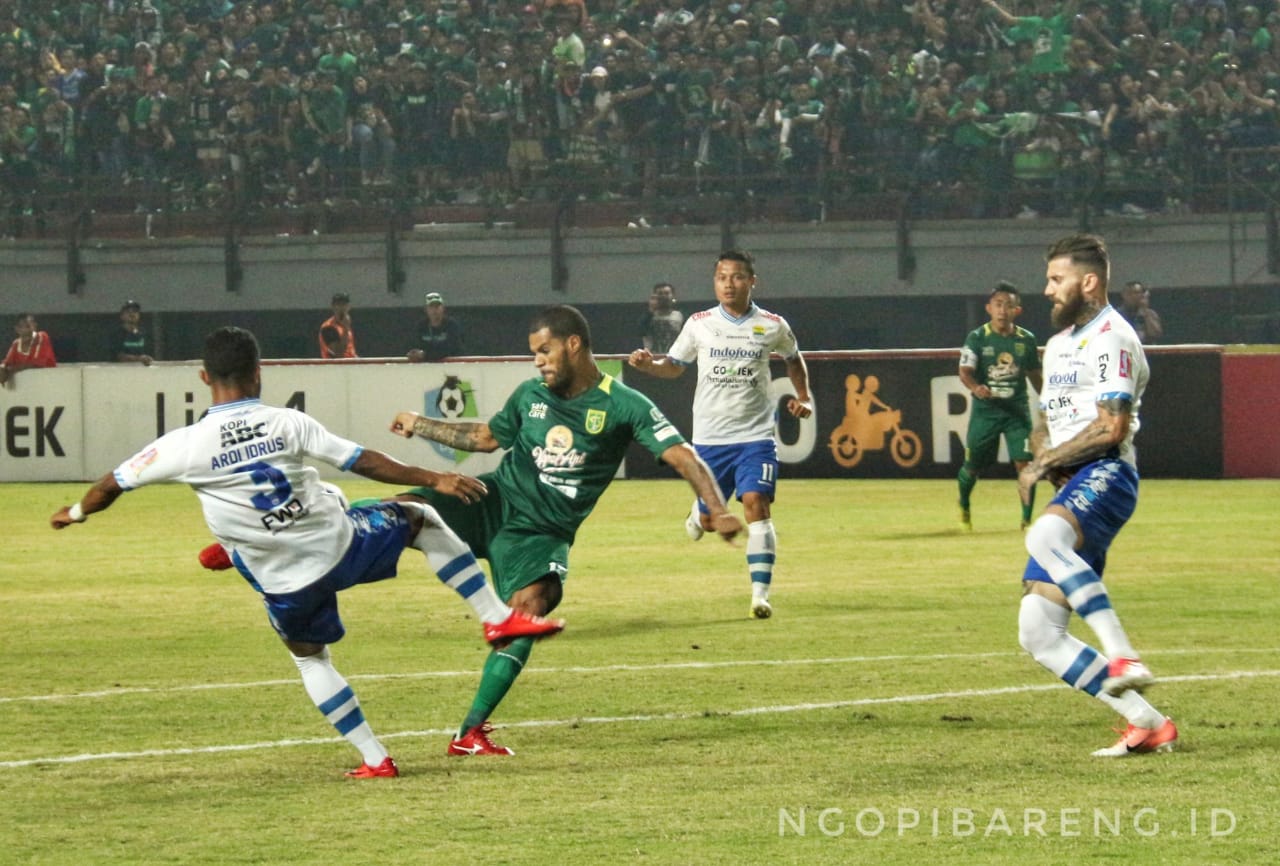 Pemain Persebaya berebut bola dengan pemain Persib Bandung. (Foto: Haris/ngopibareng.id)