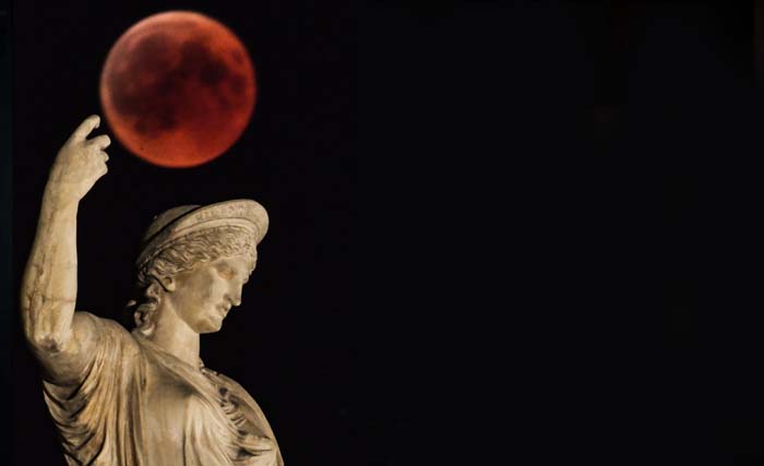 Gerhana bulan  di belakang patung Dewi Yunani Hera di Athena, 27 Juli 2018. (foto:Aris Messinis/afp) 